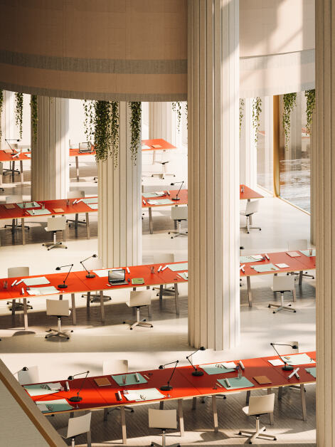 Aerial view of an office featuring four lines of adjacent DIN table frames, supporting spacious, Orange Blast linoleum tabletops with wooden edges. Each table is equipped with basic office equipment, creating a functional and organised workspace.