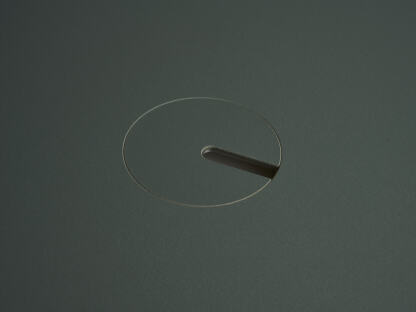 An anodised aluminum round cable lid by Daniel Lorch, covered with Conifer linoleum on one side. It sits on its tabletop cut-out hole, effectively organising cables, and protecting them from abrasion.