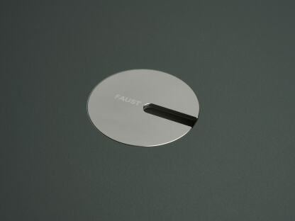 An anodised aluminum round cable lid by Daniel Lorch. It sits on its tabletop cut-out hole, effectively organising cables, and protecting them from abrasion.