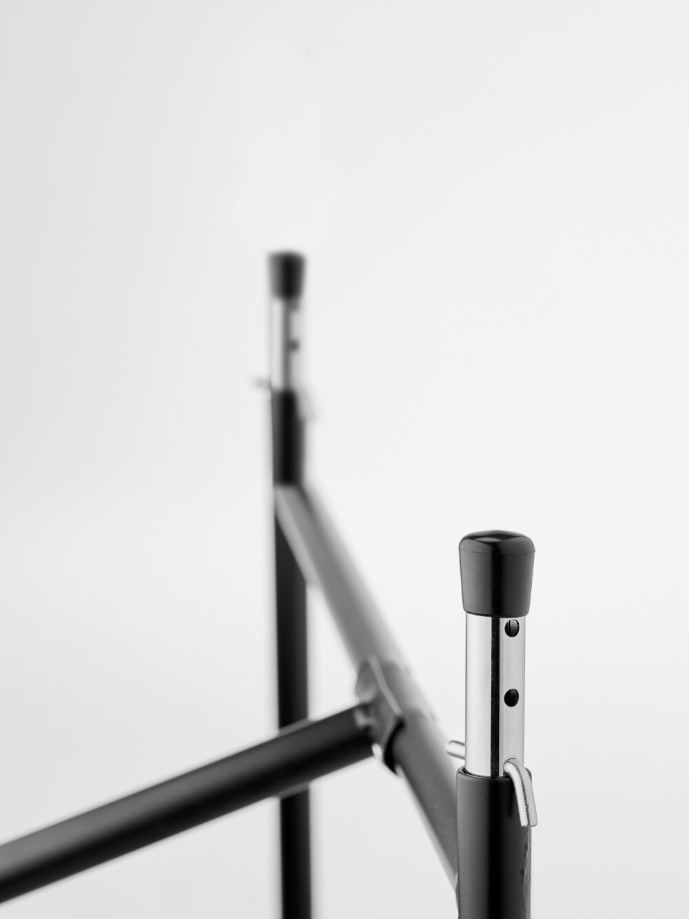 Detailed view of the height-adjustable supports with locking mechanism on the E2 table frame.
