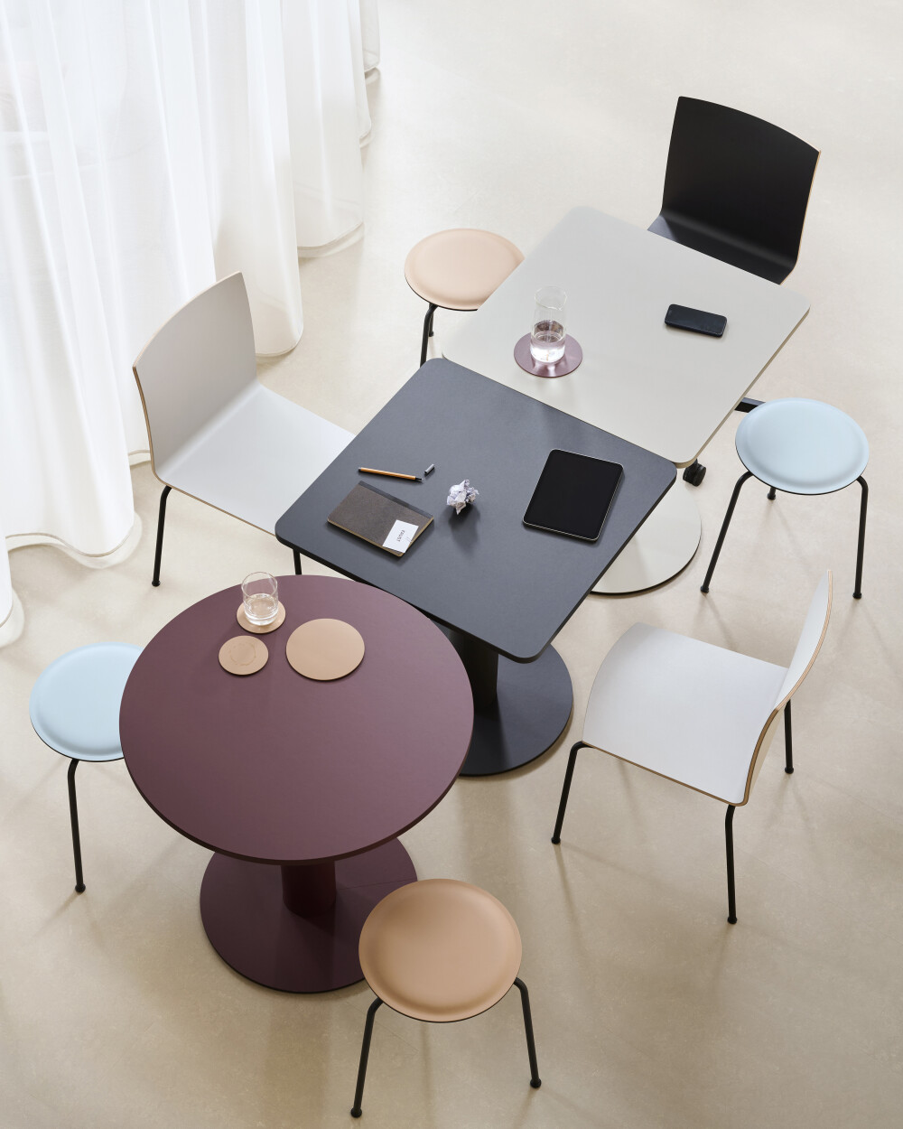 Runde und quadratische SPOT Bistrotische als modulare Arbeitsplätze für informelle Besprechungen und kollaborative Büroumgebungen.