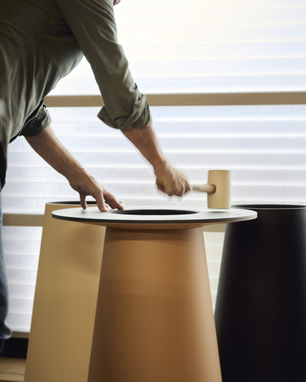 Montage eines ALT Tisches mit konischem Fuß und Linoleumplatte bei Faust – Das Tischgestell wird per Gummihammer passgenau eingesetzt.