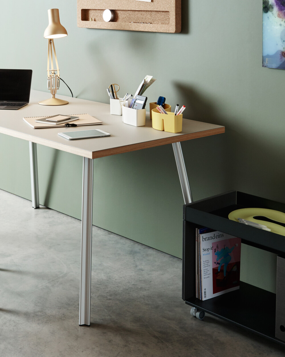 Beam Schreibtisch mit heller Platte in wohnlicher Umgebung, eingerichtet als Homeoffice mit Stuhl, Lampe und Stauraum.