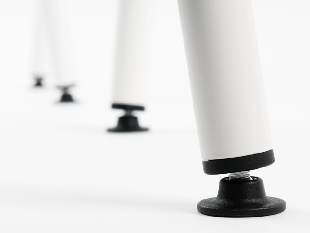 Detailaufnahme der verstellbaren Gleiter des Sinus Tischbocks, die Unebenheiten im Boden ausgleichen.