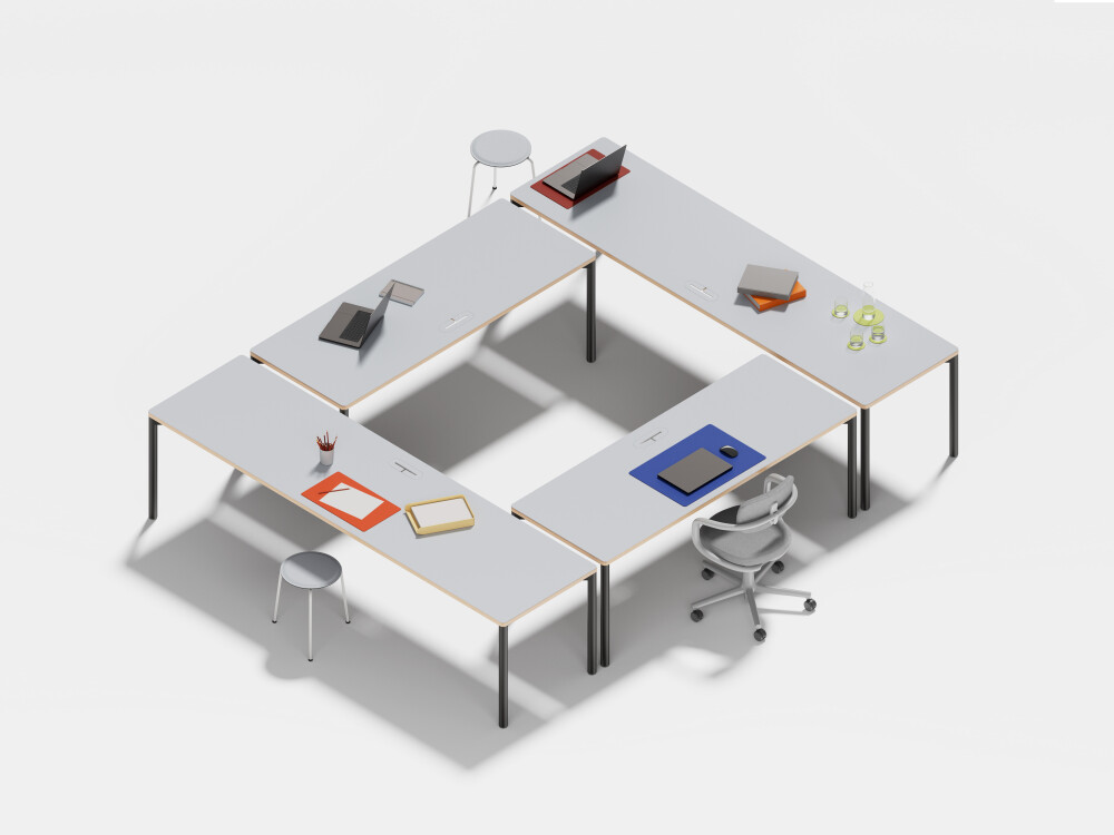 Several Outline desks by Faust in light linoleum finish with black frames combined to form a closed O-shape.